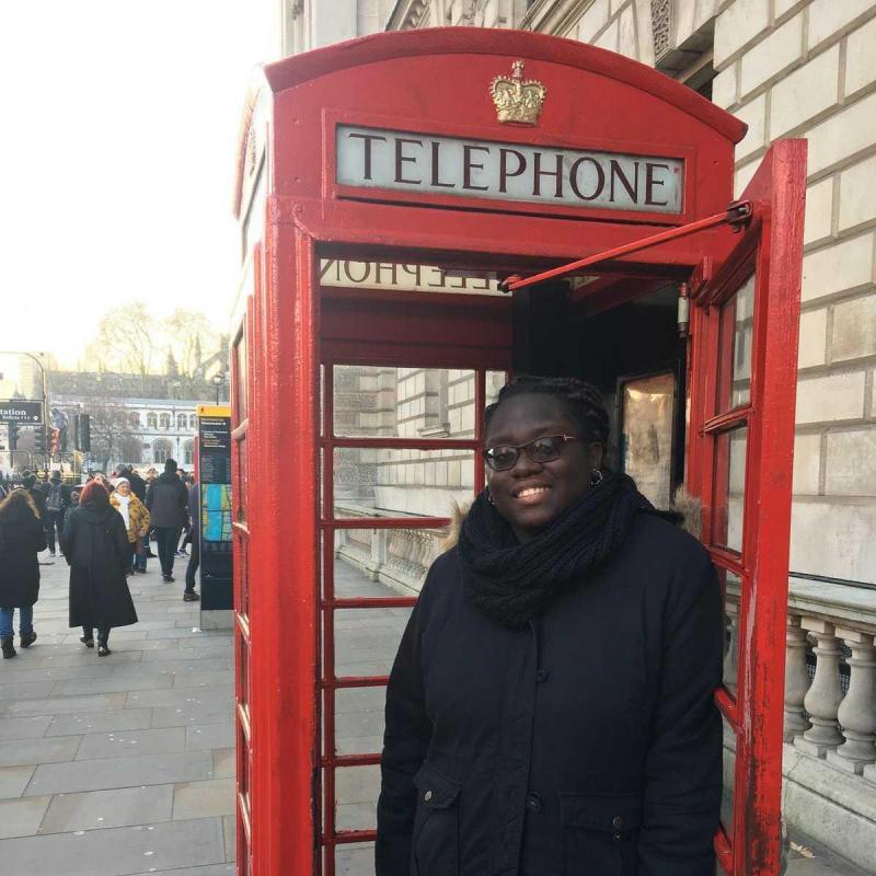 Rose Goueth inside of a London-style red telephone booth cabinet